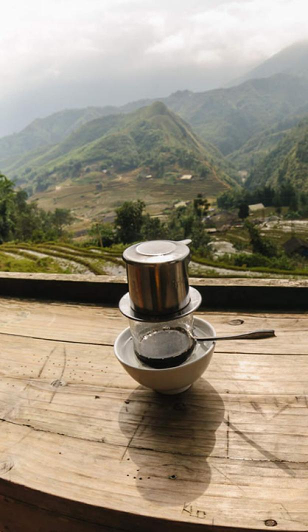 Two Vietnamese coffees on a table overlooking a valley