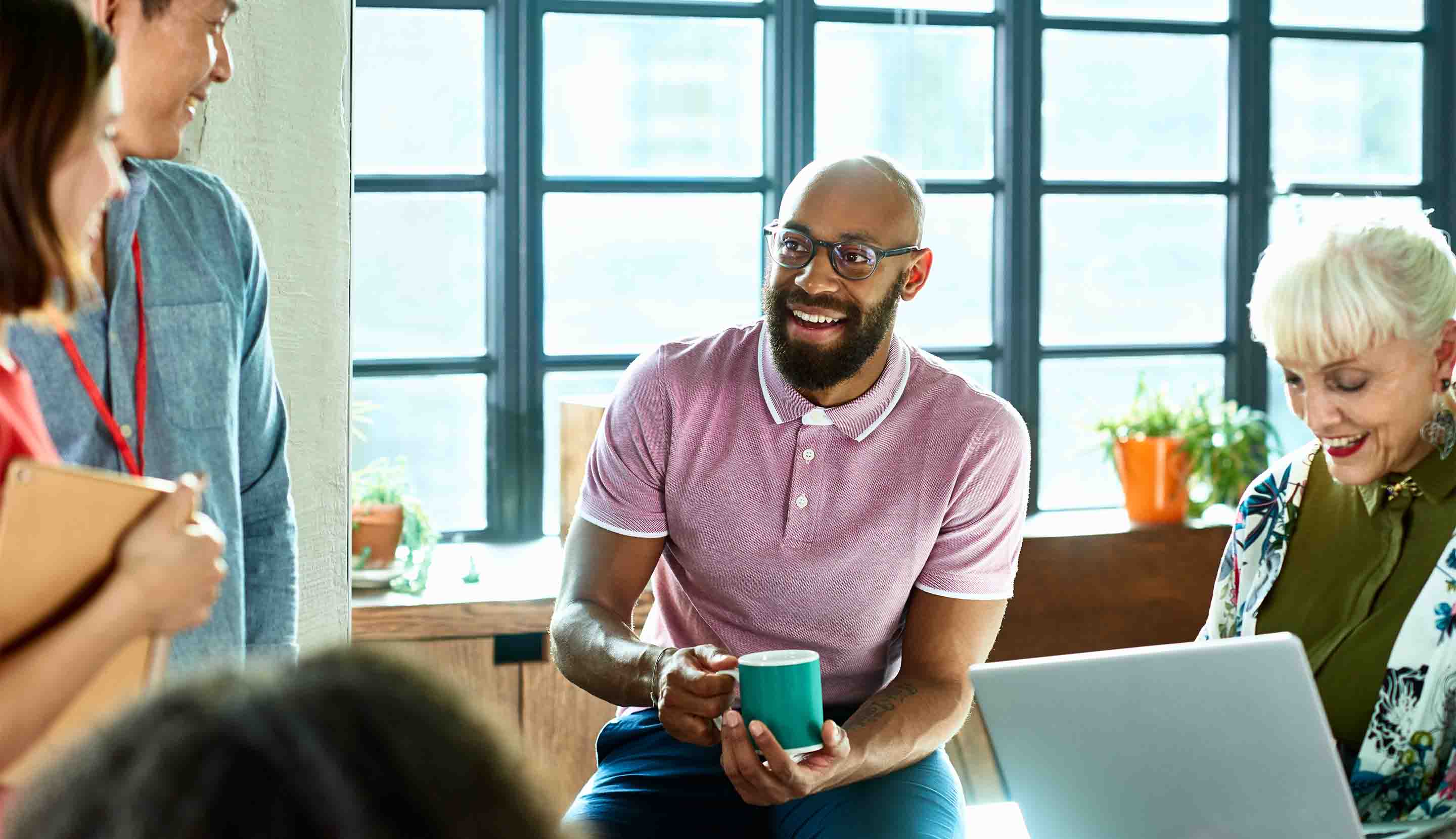 Persona en reunión de trabajo con la compañía de su café