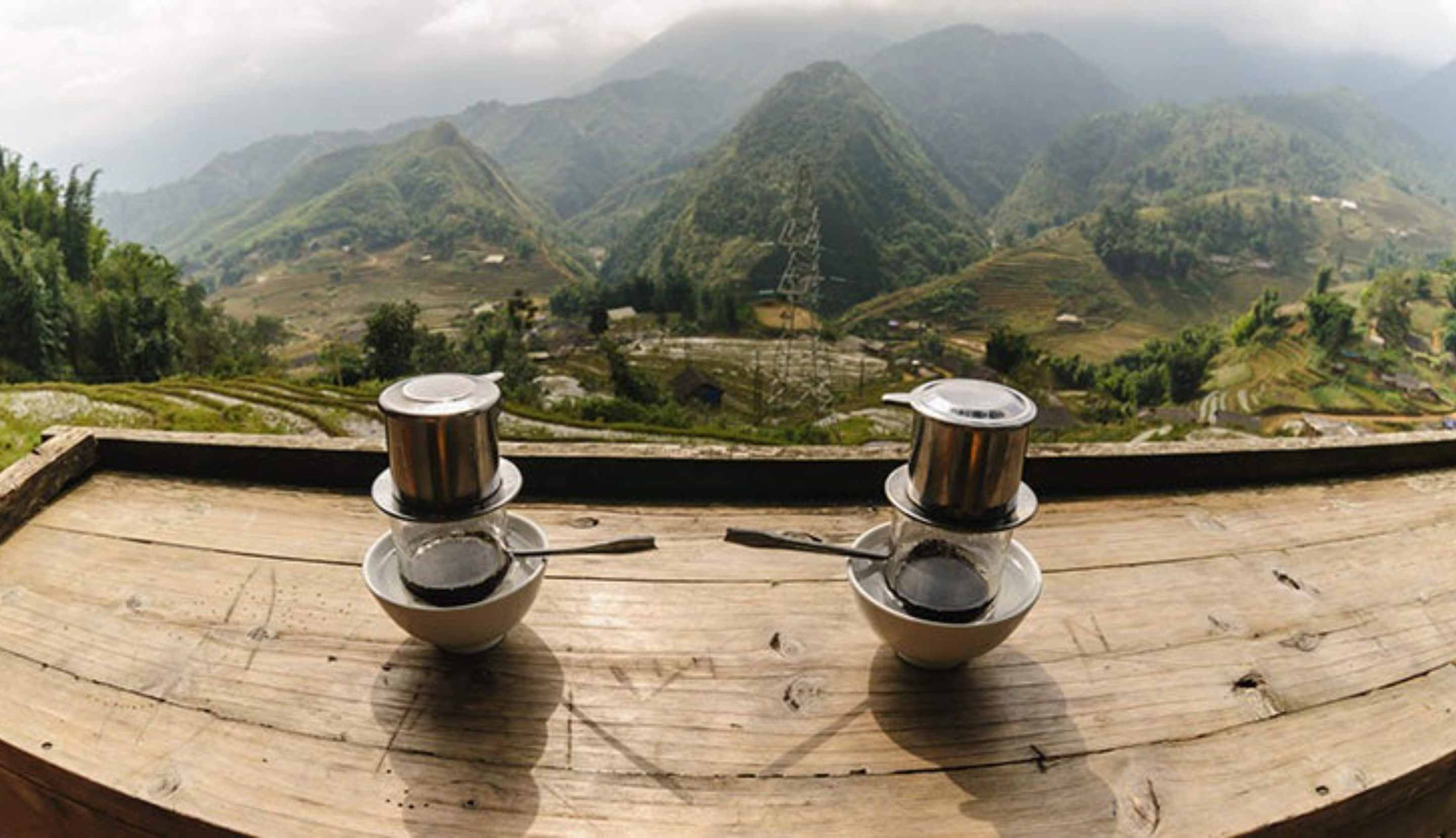 Two Vietnamese coffees on a table overlooking a valley