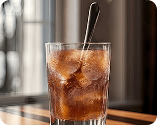 Coffee being stirred into glass.